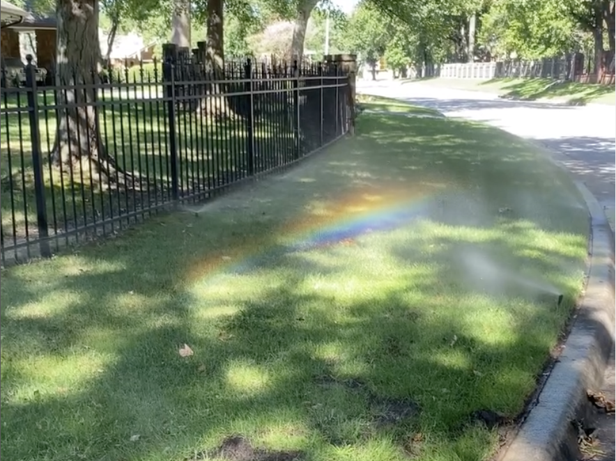 Repaired sprinkler head creating rainbow in sunlight after irrigation repair in Tulsa with Rockwell Irrigation and Landscaping